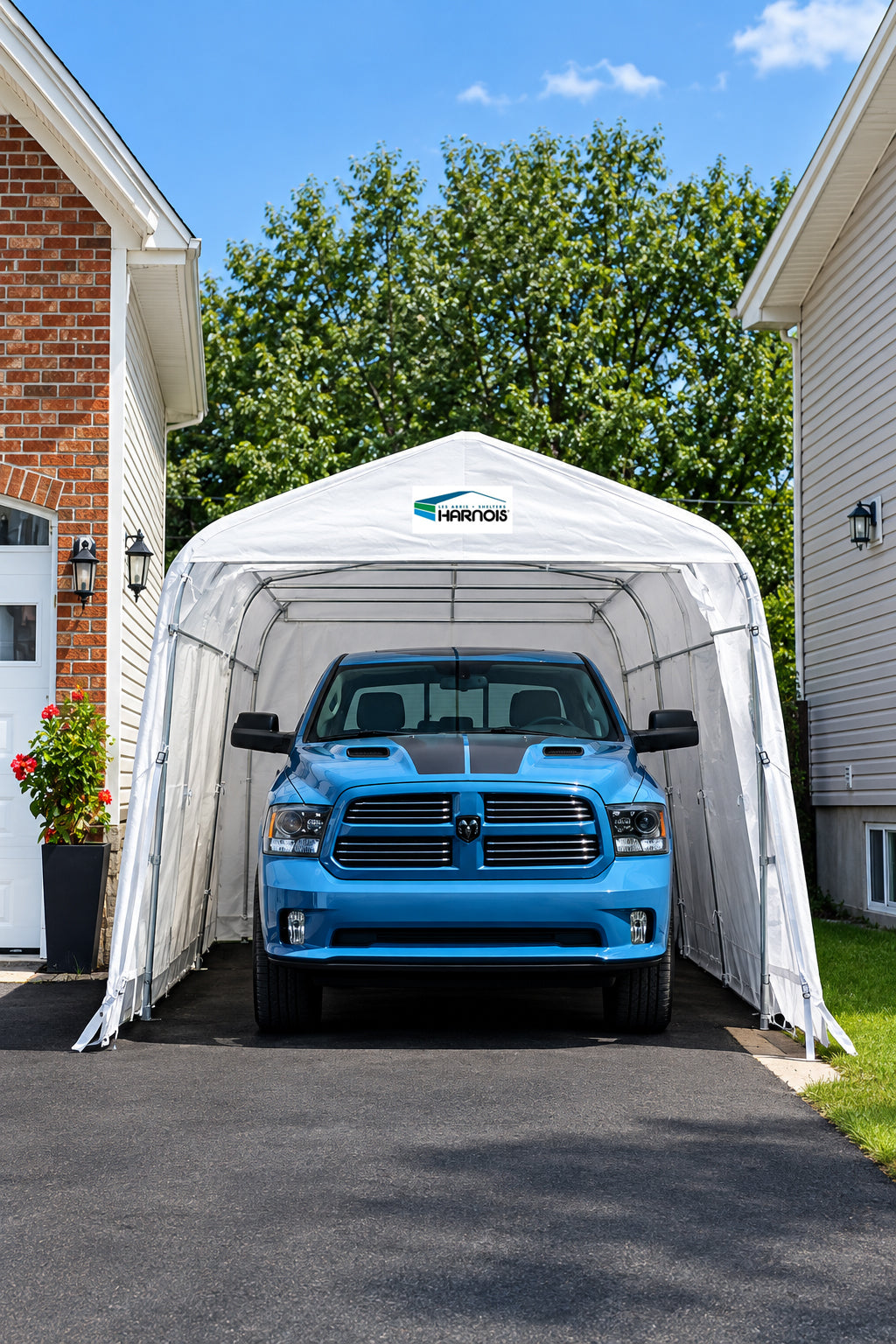 Harnois PLUS 12 car shelter installed in a driveway with a pickup truck inside